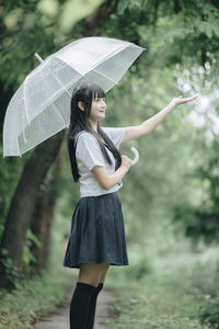 Woman with umbrella standing in rain