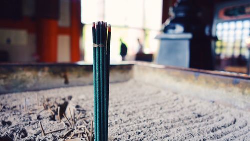 Burning incense sticks in container at temple