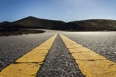 Road by mountain against clear sky