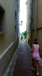 Rear view of woman walking on street in city