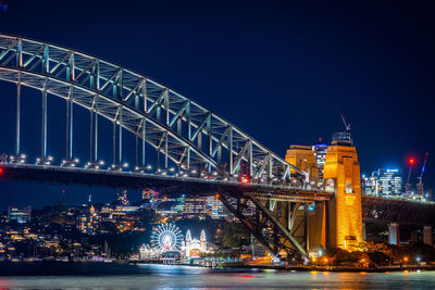 Illuminated bridge over river at night