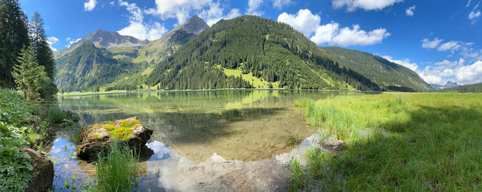 Scenic view of lake by mountains against sky