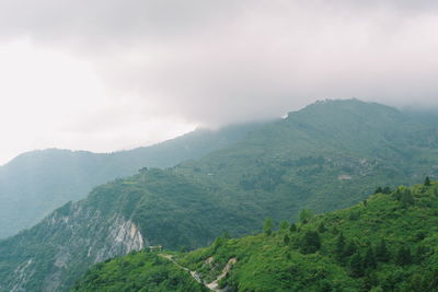 Scenic view of mountains against cloudy sky