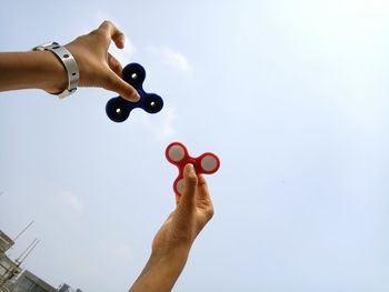 Low angle view of hand against sky