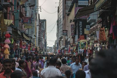 Crowd on city street against sky