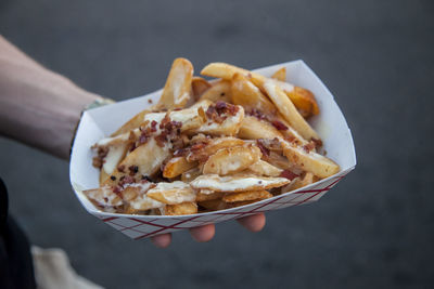 Cropped hand of man holding french fries