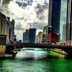 Buildings with waterfront against cloudy sky