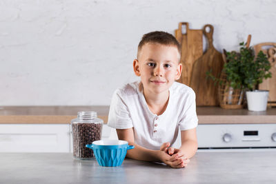 Portrait of boy standing by breakfast at home