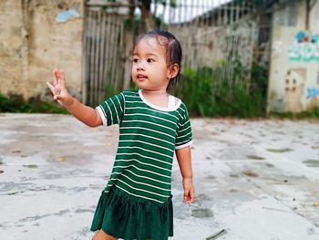 Cute boy looking away while standing outdoors