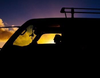 Close-up of silhouette vehicle against sky during sunset