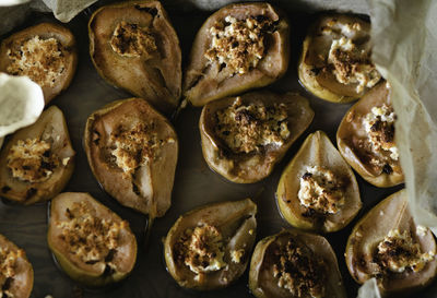 Halves of tasty baked pears with maple syrup and cinnamon on wax paper