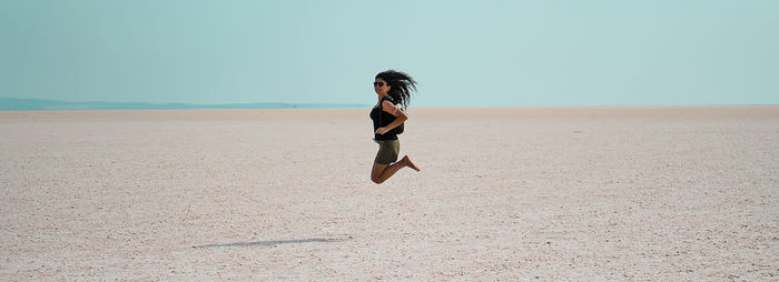 Full length of woman on sand dune against sky