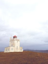 Low angle view of lighthouse against cloudy sky