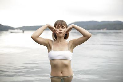 Portrait of woman standing against sea