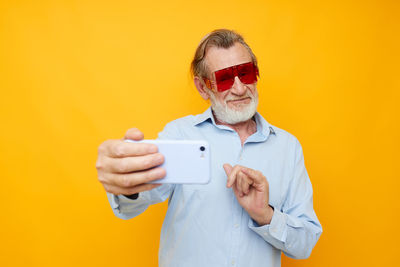 Senior man gesturing while taking selfie