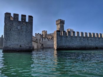 Buildings by sea against sky