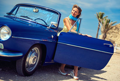 Portrait of woman standing by car