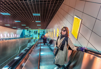 Woman standing on escalator