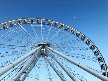 Low angle view of ferris wheel against blue sky