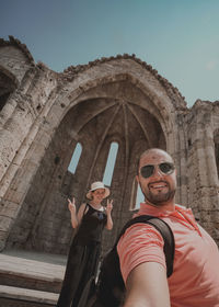 Low angle view of man wearing sunglasses against sky