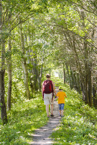 Mother with son walking through forest