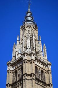 Low angle view of toledo cathedral against clear blue sky in city