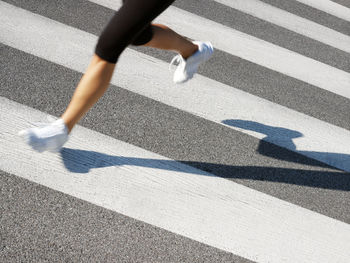 Low section of person running on road