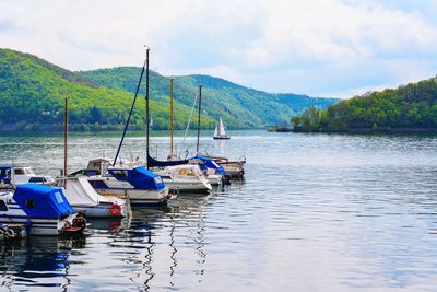 Boats moored in lake against sky