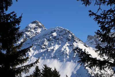 Low angle view of snowcapped mountains against clear sky