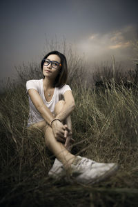 Portrait of young woman sitting on field