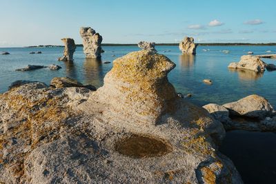 Rocks at beach against sky