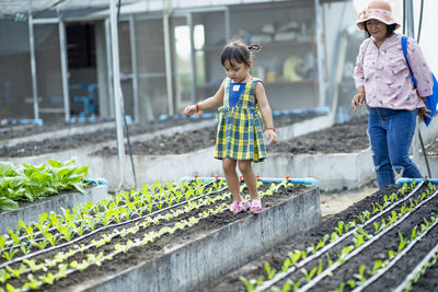 Portrait of siblings standing in greenhouse