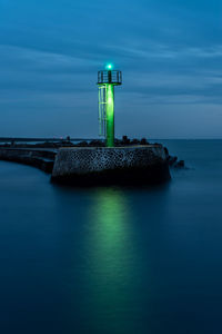 Stone pier in darlowo in the evening. lights on the beach. traffic lights in the port. blue hour. 