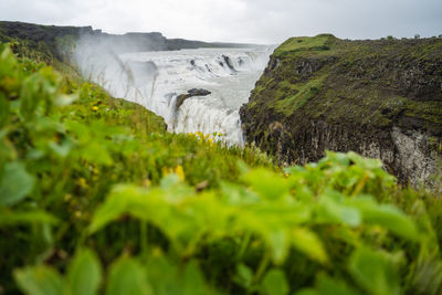 Scenic view of waterfall against sky
