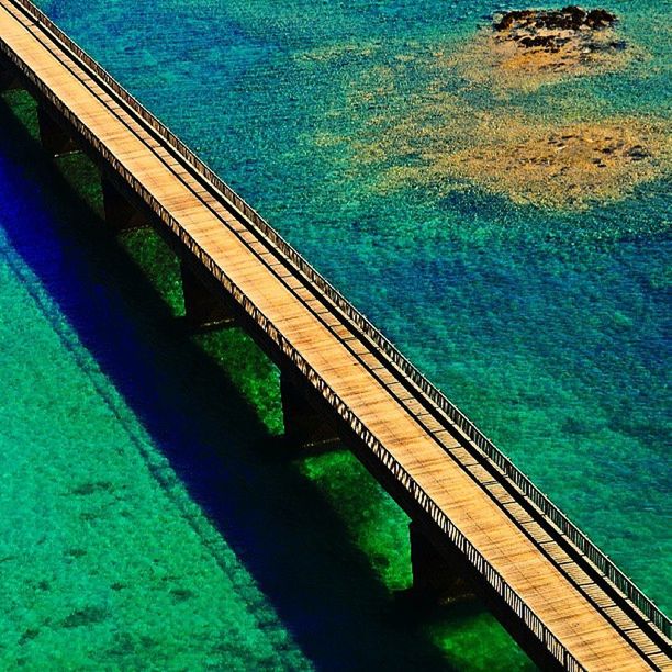 water, blue, sea, high angle view, built structure, railing, architecture, swimming pool, nature, tranquility, green color, connection, pier, beauty in nature, reflection, bridge - man made structure, waterfront, turquoise colored, tranquil scene, outdoors