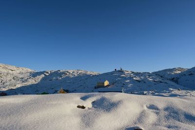 Scenic view of snowcapped mountains against clear blue sky