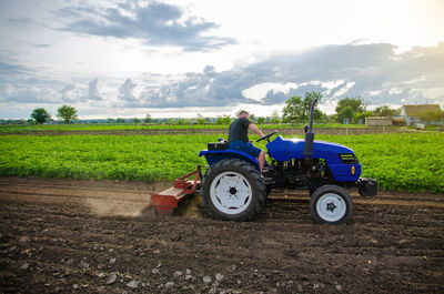 A farmer on a tractor mills and cultivates an agricultural field. milling soil, crushing 