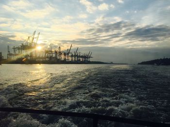 Scenic view of sea against cloudy sky during sunrise