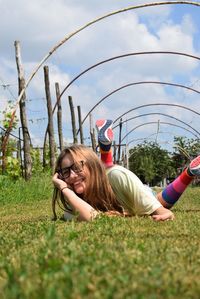 Portrait of smiling young woman lying on field