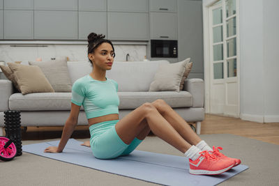 Portrait of young woman sitting on sofa at home