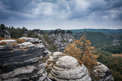 Rock formations against cloudy sky at saxon switzerland