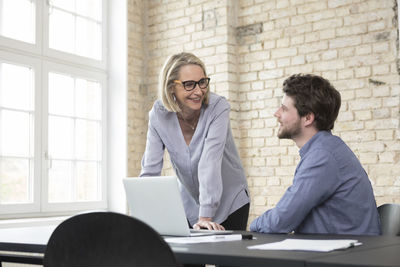 Mature businesswoman working with younger colleague in office