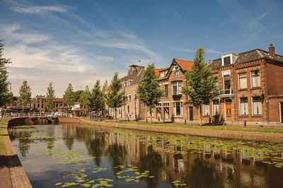 Scenic view of lake by buildings against sky