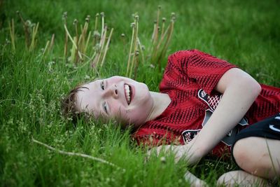 Young woman lying on grassy field