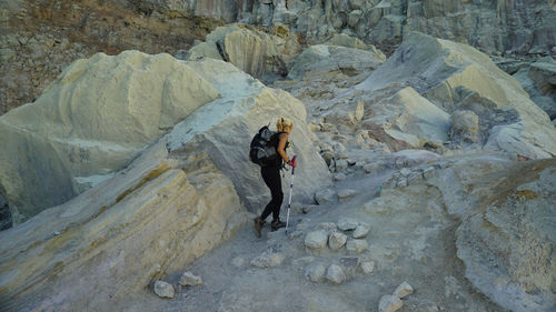 Full length of man standing on rock in mountains