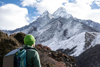 Rear view of man looking at mountains during winter