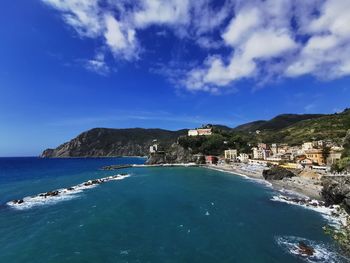 Scenic view of sea by buildings against sky