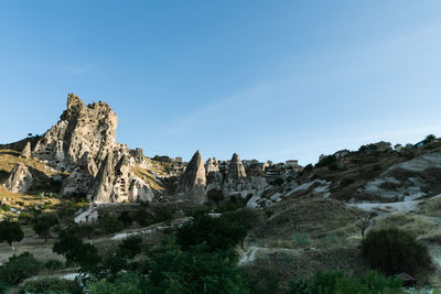 Panoramic view of rocky mountains against blue sky