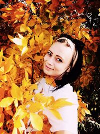 Portrait of young woman with autumn leaves