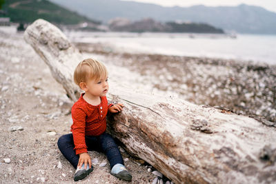 Full length of cute boy on rock